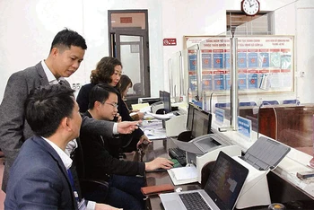 Người dân được cán bộ ở Bộ phận Một cửa của Ủy ban nhân dân xã Cẩm La, thị xã Quảng Yên hướng dẫn làm thủ tục hành chính trực tuyến.