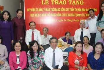 Đồng chí Nguyễn Văn Nên, Ủy viên Bộ Chính trị, Bí thư Thành ủy Thành phố Hồ Chí Minh và các đại biểu chụp hình lưu niệm với nhà thơ Lê Giang và nhạc sĩ Lư Nhất Vũ.