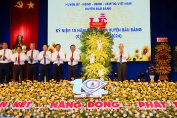 Nguyên Chủ tịch nước Nguyễn Minh Triết trao tặng lẵng hoa chúc mừng huyện Bàu Bàng. 