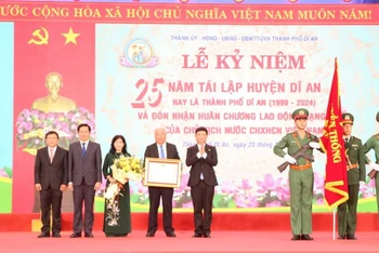 Thừa ủy nhiệm, Chủ tịch Ủy ban nhân dân tỉnh Bình Dương Võ Văn Minh trao Huân chương Lao động hạng Nhất cho Đảng bộ, chính quyền và nhân dân thành phố Dĩ An.