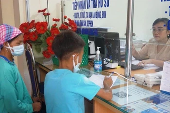 Phụ huynh ở huyện Bát Xát (Lào Cai) đưa học sinh đến mua bảo hiểm y tế học đường.
