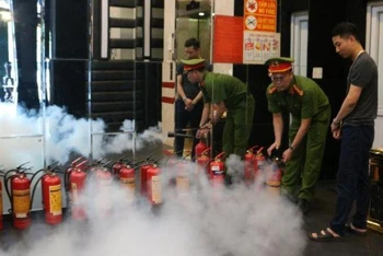 Công an thành phố Thái Bình hướng dẫn nhân viên cơ sở kinh doanh dịch vụ karaoke sử dụng bình bọt cầm tay xử lý ban đầu khi phát hiện cháy.