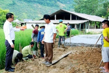 Bí thư Đảng ủy thị trấn Phong Hải Vũ Trung Dũng (áo trắng, bìa trái) kiểm tra đổ bê tông đường giao thông đến hộ gia đình ở thôn Ải Nam, chủ yếu là đồng bào dân tộc thiểu số sinh sống.
