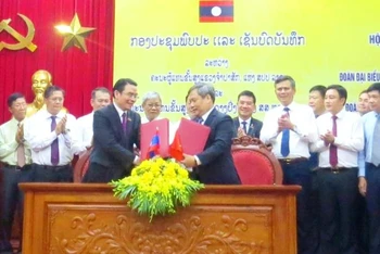 Trưởng đoàn đại biểu cấp cao 2 tỉnh Quảng Bình và Champasak trao biên bản hợp tác.