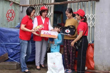 Các tình nguyện viên Hội Chữ thập đỏ trao túi sơ cứu, túi hàng cho hộ thuê trọ.