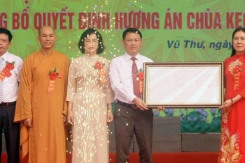 Thừa ủy quyền của Thủ tướng Chính phủ, bà Trần Thị Bích Hằng, Phó Chủ tịch Ủy ban nhân dân tỉnh Thái Bình (bên phải) trao Quyết định của Thủ tướng Chính phủ công nhận Hương án chùa Keo là bảo vật quốc gia.