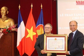 Đại sứ Đinh Toàn Thắng trao Huân chương Hữu nghị cho nhà sử học Alain Ruscio. (Ảnh: Khải Hoàn)