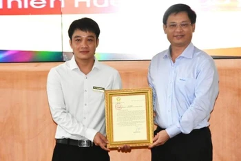 Phó Chủ tịch Thường trực UBND tỉnh Thừa Thiên Huế Nguyễn Thanh Bình (bên phải) trao Thư khen của Chủ tịch nước cho anh Tô Vũ Đồng.