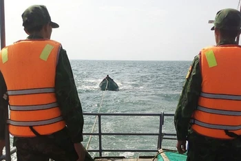 Cán bộ, chiến sĩ Biên phòng Hải đội 2, Bộ đội Biên phòng tỉnh Kiên Giang lai dắt tàu bị nạn về xã Tiên Hải. (Ảnh: Biên phòng cung cấp)