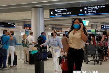 Hành khách đeo khẩu trang phòng lây nhiễm Covid-19 tại sân bay ở Miami, Florida, Mỹ. (Ảnh: AFP/TTXVN)