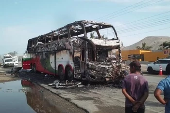 Chiếc xe buýt và xe chở khách 3 bánh bị cháy rụi sau vụ tai nạn. (Nguồn: Diario Correo)