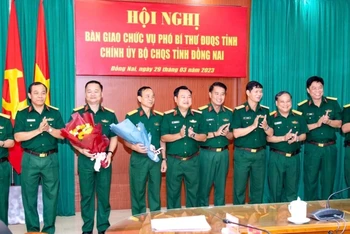 Các đại biểu dự Hội nghị tặng hoa chúc mừng Đại tá Bùi Đăng Ninh được bổ nhiệm chức vụ mới và Đại tá Huỳnh Thanh Liêm nhận quyết định nghỉ chờ hưu.