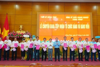 Phó Bí thư Thường trực Tỉnh ủy Đồng Tháp Phan Văn Thắng và Phó Bí thư Đảng ủy Khối Doanh nghiệp Trung ương Hồ Xuân Trường trao quyết định, tặng hoa chúc mừng 16 tổ chức đảng.