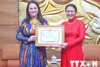 Chủ tịch Liên hiệp các tổ chức hữu nghị Việt Nam Nguyễn Phương Nga trao Kỷ niệm chương cho Trưởng đại diện UN Women tại Việt Nam Elisa Fernandez Saenz. (Ảnh: Như Quỳnh/TTXVN phát)