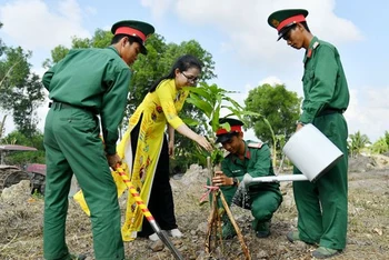 Cán bộ, chiến sĩ Trung đoàn Bộ binh 893 và thanh niên, phụ nữ trên địa bàn đơn vị đóng quân cùng tham gia trồng cây xanh. 
