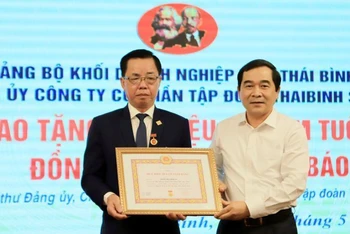 Phó Bí thư Thường trực Tỉnh ủy Thái Bình Nguyễn Tiến Thành (bên phải) trao Huy hiệu 50 năm tuổi Đảng cho đồng chí Trần Mạnh Báo.