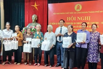 Phó Giám đốc Sở Lao động, Thương binh và Xã hội Hà Nội trao tặng các phần quà động viên những người mẹ, người vợ có công chăm sóc, nuôi dưỡng nạn nhân chất độc da cam.