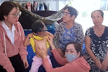 Lực lượng chức năng huyện Đầm Dơi (tỉnh Cà Mau) kiểm tra vết thương trên cơ thể cháu bé có dấu hiệu bị bạo hành.