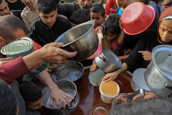 Người dân chờ nhận lương thực viện trợ ở thành phố Rafah, phía Nam dải Gaza. (Ảnh: THX/TTXVN)