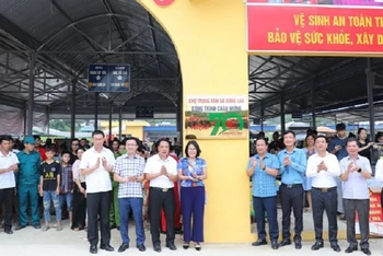 Các đồng chí lãnh đạo huyện Mường Ảng cùng các đại biểu, nhân dân huyện Mường Ảng gắn biển công trình chợ trung tâm xã Búng Lao.