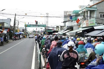 Người dân từ phía Đồng Nai xếp hàng dài qua phà Cát Lái di chuyển về Thành phố Hồ Chí Minh chiều 3/9. (Ảnh: QUÝ HIỀN)