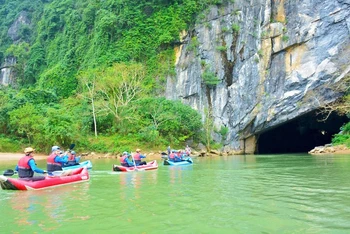 Du khách chèo kayak khám phá động Phong Nha. (Ảnh: Báo Nhân Dân)