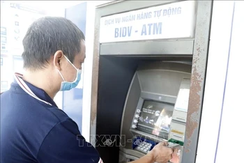 Người dân sử dụng thẻ nội địa tại máy rút tiền tự động của BIDV. (Minh họa: Trần Việt/TTXVN)