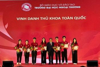 Hiệu trưởng Trường đại học Ngoại thương PGS, TS Bùi Anh Tuấn trao Giấy khen và Huy hiệu cho các thủ khoa toàn quốc trở thành tân sinh viên của trường năm 2023.