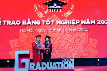 Hiệu trưởng Trường đại học Ngoại thương Phó Giáo sư, Tiến sĩ Bùi Anh Tuấn trao bằng tốt nghiệp cho thủ khoa tốt nghiệp Nguyễn Khánh Linh và các tân cử nhân. 