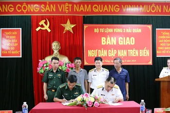 Đại diện Bộ Tư lệnh Vùng 3 Hải quân và Đồn Biên phòng Sơn Trà ký giao, nhận hai ngư dân gặp nạn.