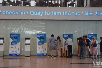 Du khách làm thủ tục tự động self check-in kiosk tại Nhà ga Quốc tế Đà Nẵng chiều ngày 2/8. 