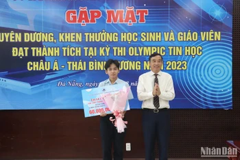 Chủ tịch UBND thành phố Lê Trung Chinh tặng Bằng khen và tiền thưởng cho học sinh Lê Ngọc Bảo Anh. (Ảnh: ANH ĐÀO)