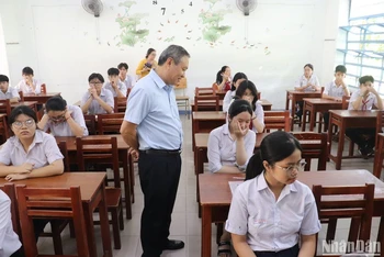 Ông Mai Tấn Linh, Phó Giám đốc Sở GD-ĐT TP Đà Nẵng thăm hỏi, động viên thí sinh ổn định tâm lý, vượt qua sự cố về sức khoẻ để làm bài thật tốt. (Ảnh ANH ĐÀO)