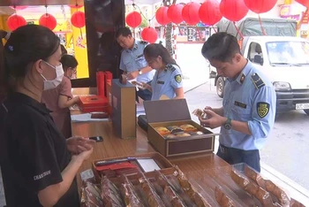 Cán bộ Cục Quản lý thị trường tỉnh Hà Nam kiểm tra nguồn gốc, xuất xứ của các loại bánh trung thu được bày bán trên thị trường.