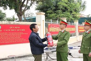 Công an phường Thanh Tuyền, thành phố Phủ Lý đổi vũ khí lấy bình chữa cháy do người dân giao nộp.