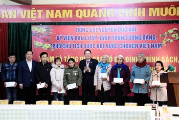 Phó Chủ tịch Quốc hội Nguyễn Đức Hải (giữa) và Bí thư Tỉnh ủy Hòa Bình (thứ 2 từ trái sang) tặng quà Tết cho các gia đình khó khăn.