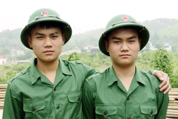 Hai anh em song sinh Bùi Thế Huynh (trái) và Bùi Anh Tuấn (phải) tự hào được khoác lên mình quân phục của người lính.