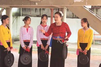 Bà Dung đang dạy Chiêng Mường cho các cháu.