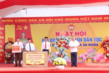 Đồng chí Nguyễn Hòa Bình (trái) tặng quà cho nhân dân trong xã.