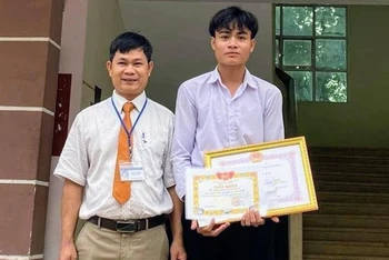 Đại diện Ban giám hiệu Trường Trung học phổ thông Nguyễn Du trao giấy khen cho em Kpắ Y Sem.