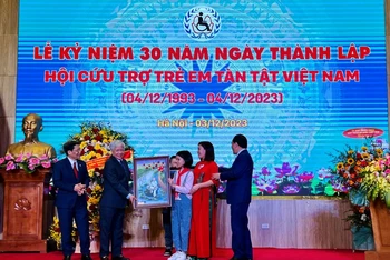Đại diện trẻ em khuyết tật nhận quà tặng từ Ủy ban Trung ương Mặt trận Tổ quốc Việt Nam.