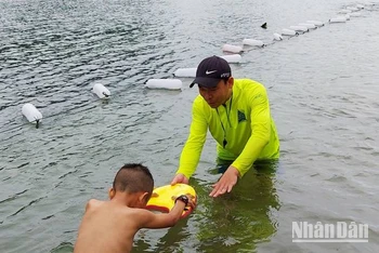 Kỹ thuật viên của Công ty du lịch Chua me đất dạy bơi cho trẻ em ở thị trấn Phong Nha.