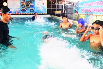 Giáo viên ở Lệ Thủy, Quảng Bình dạy bơi cho học sinh. (Ảnh: Hương Giang)