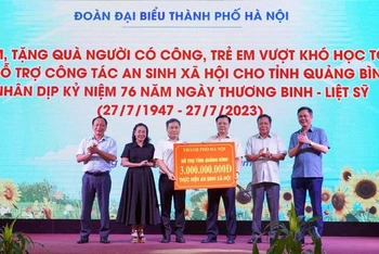 Ủy viên Bộ Chính trị, Bí thư Thành ủy Hà Nội Đinh Tiến Dũng trao hỗ trợ an sinh xã hội cho tỉnh Quảng Bình. (Ảnh Ngọc Mai)