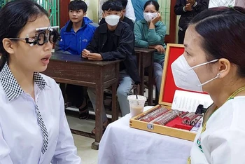 Bác sĩ khám mắt cho sinh tại Quảng Bình thông qua một chương trình khám bệnh từ thiện.