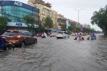 Đường Trần Hưng Đạo, tuyến đường chính của thành phố Đồng Hới ngập sâu một đoạn, gây khó khăn cho người và phương tiện qua lại.