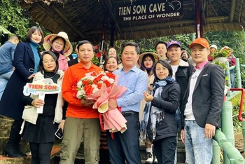 Giám đốc Trung tâm Du lịch Phong Nha-Kẻ Bàng Hoàng Minh Thắng tặng hoa những du khách đầu tiên tham quan động Tiên Sơn sau ngày mở cửa trở lại.