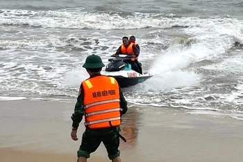 Lực lượng chức năng ở Quảng Bình dùng mô-tô nước đưa ngư dân bị chìm thuyền trên biển vào bờ.