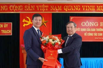Bí thư Tỉnh ủy Quảng Bình Vũ Đại Thắng trao quyết định, tặng hoa chúc mừng Bí thư Huyện ủy Quảng Trạch Nguyễn Chí Thắng (bên trái).