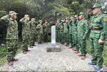 Lực lượng bảo vệ biên giới 2 nước Việt Nam và Lào làm lễ chào cột mốc quốc giới.